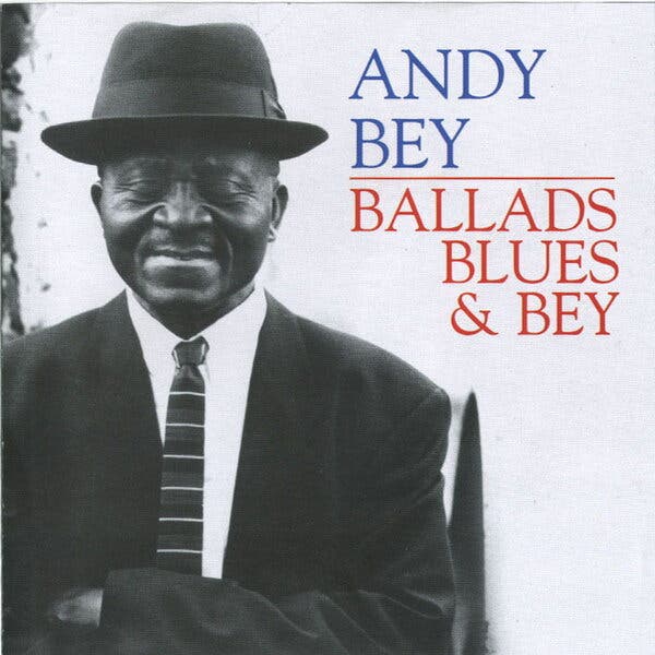 The cover of “Ballads, Blues & Bey.” His name is in blue type and the title is in red beside a black and white photo of Mr. Bey with his eyes shut. He is in a dark suit and tie and wears a dark brimmed hat.